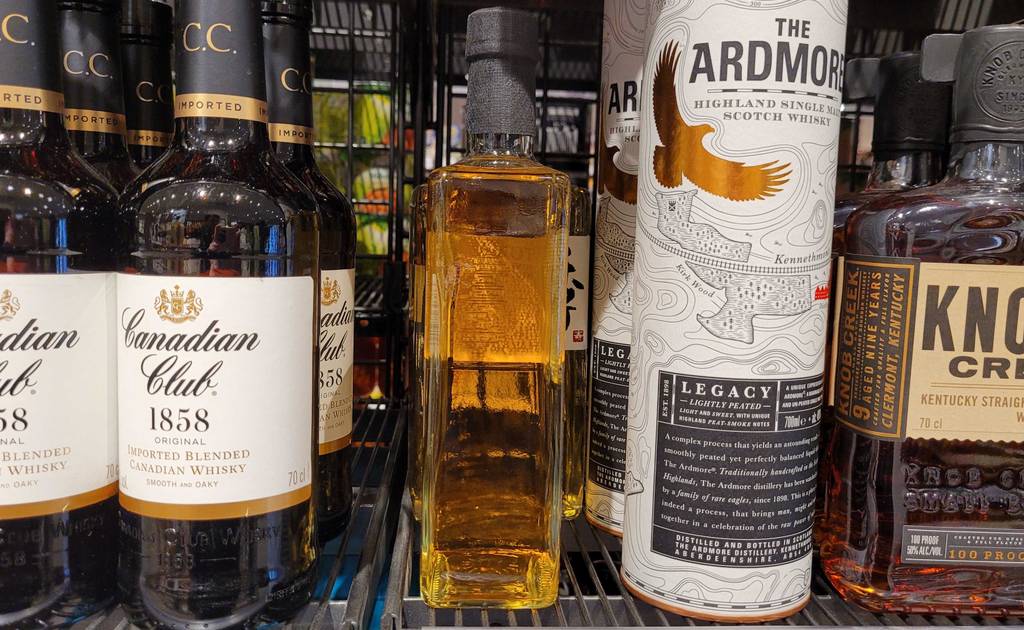 Eine Flasche inklusive versiegeltem Verschluss mit einem goldbraunen japanischen Whisky im Test zwischen anderen Spirituosen.