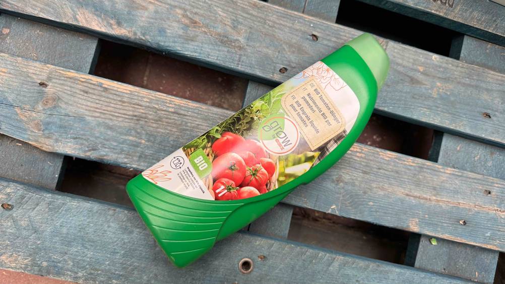 Tomatendünger getestet: Eine Flasche liegt horizontal auf einer Palette.