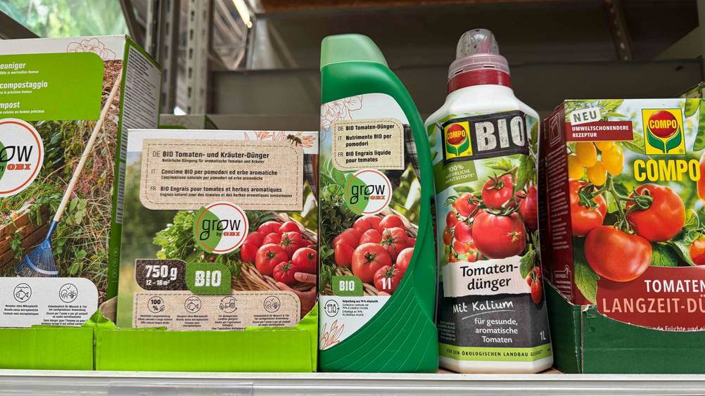 In einem Regal stehen die getesteten Tomatendünger neben anderen Produkten.