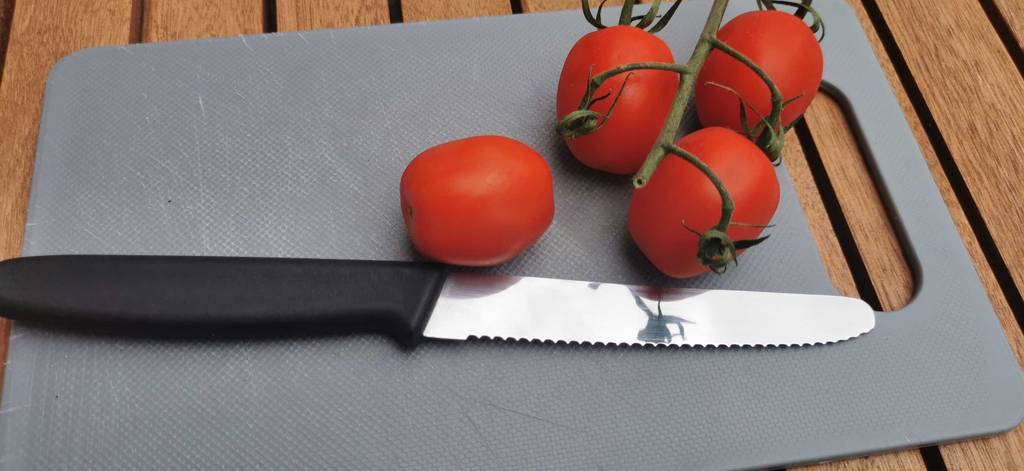 tomatenmessser-test: Tomaten mit Tomatenmesser auf einem Küchenbrett