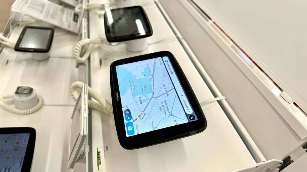 Ein getestetes Lkw-Navi liegt neben weiteren Navis eingeschaltet in einem Ausstellungsbereich.