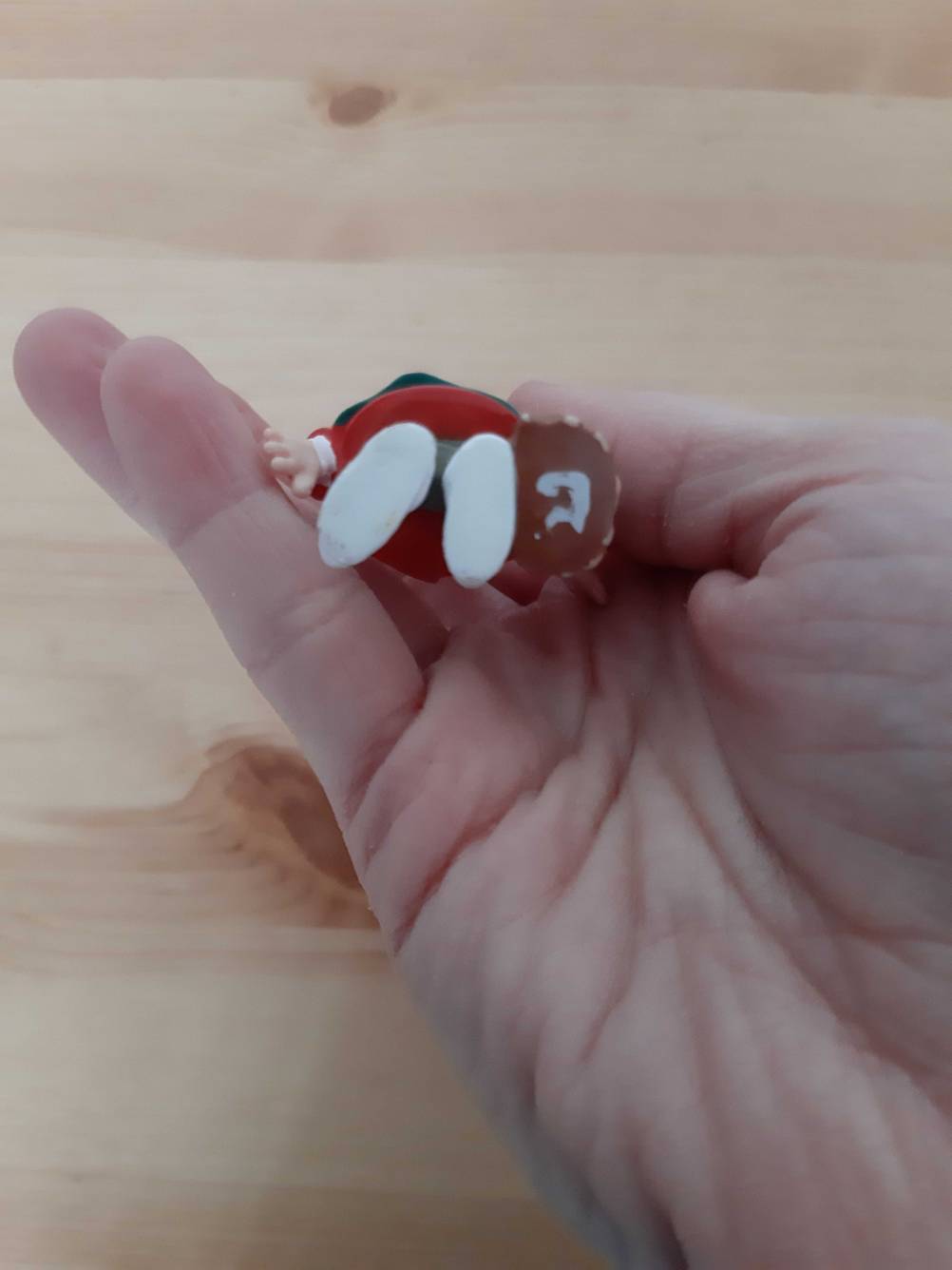 Eine Hand hält eine getestete Tonie-Figur mit den Füßen nach oben.