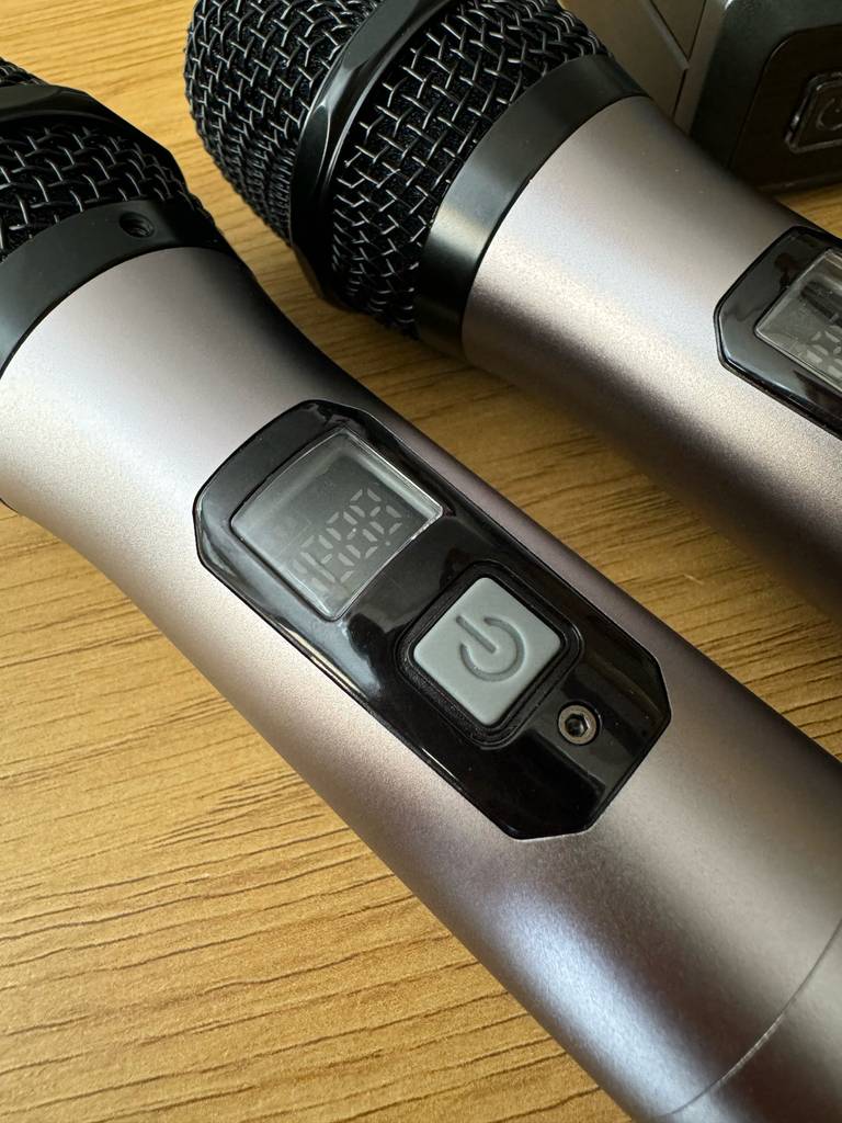 Zwei Funkmikrofone im Test liegen auf einer Holzoberfläche.