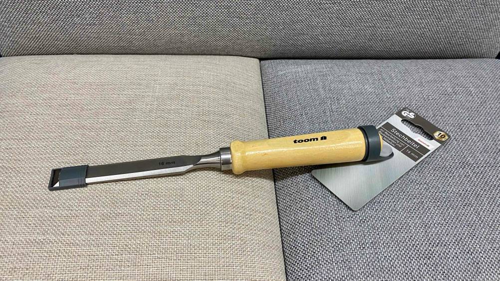 Im Test: Ein Stechbeitel mit Label liegt auf einem Polster in beige-grau.
