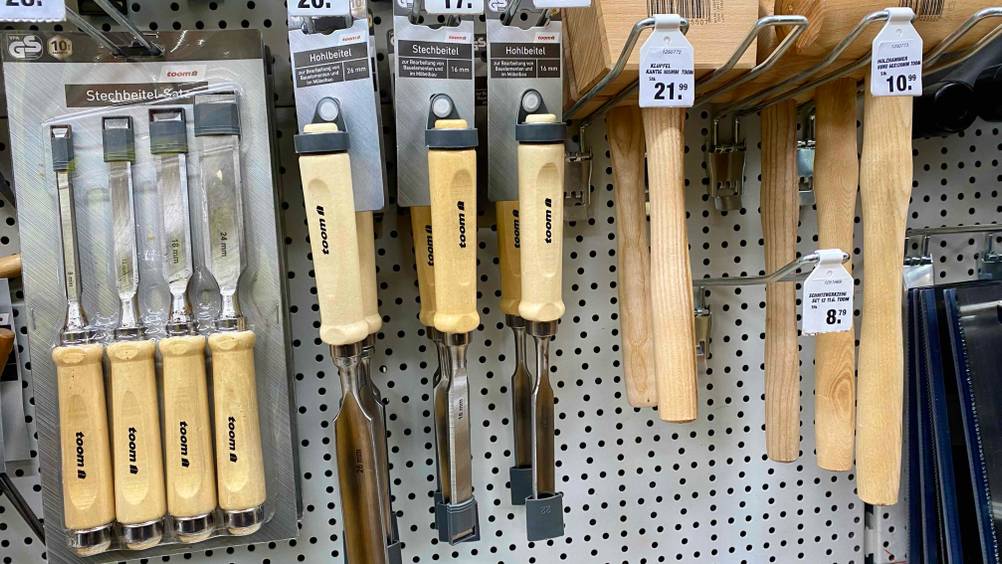 Mehrere getestete Stechbeitel hängen neben anderen Produkten in einem Regal inklusive Preisangaben.