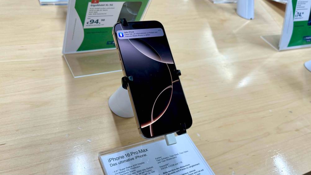 Ein Top-Handy im Test von schräg oben auf einem Ständer in einer Verkaufsfläche mit Informationen.