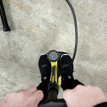 Ein Fahrradreifen wird mit der Topeak Joe Blow Sport III aufgepumpt. Die Füße stabilisieren die Pumpe auf dem Boden.