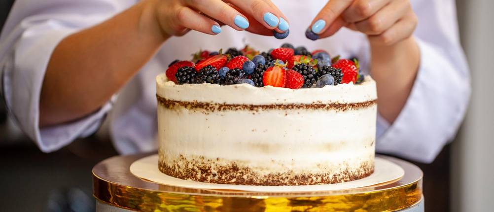 Torten-Deko-Test: Frau dekoriert Torte mit Obst