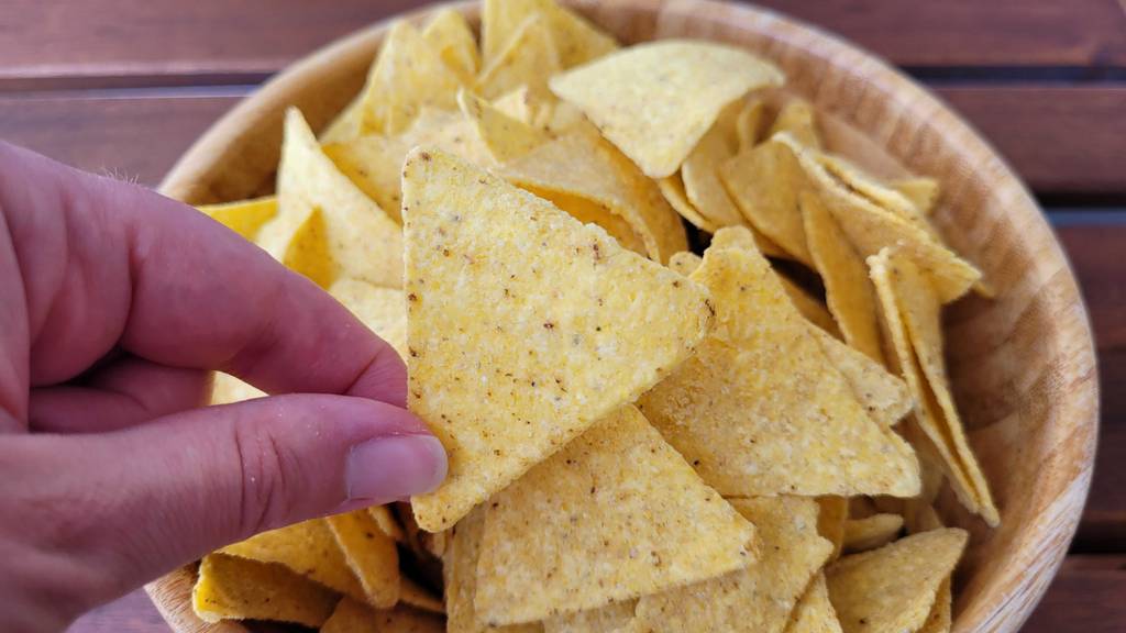 tortilla-chip wird aus Schüssel genommen