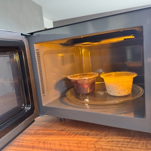 Geöffnete Toshiba MW2-AG23PF(BK) mit Fertiggericht im Inneren