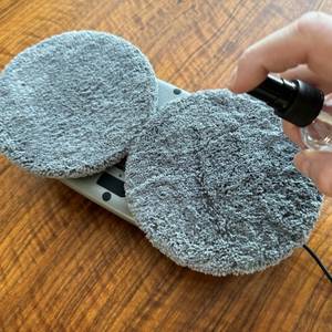 Eine Hand strüht etwas auf die Pads des Tosima W2