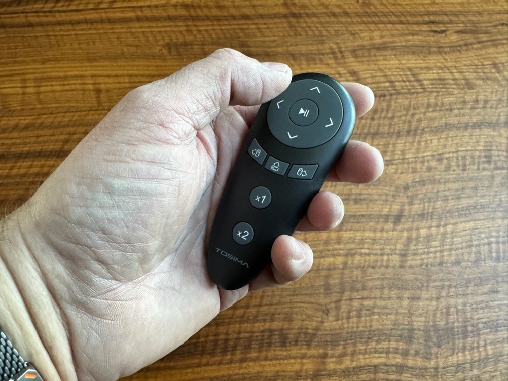 Eine Hand hält die Fernbedienung des Tosima W2 fest