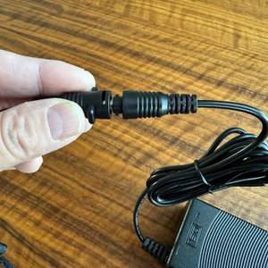 Eine Hand hält das Stromkabel des Tosima W2 in der Hand