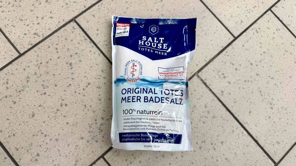 Eine Packung Totes-Meer-Badesalz von oben auf einem Fließenboden.
