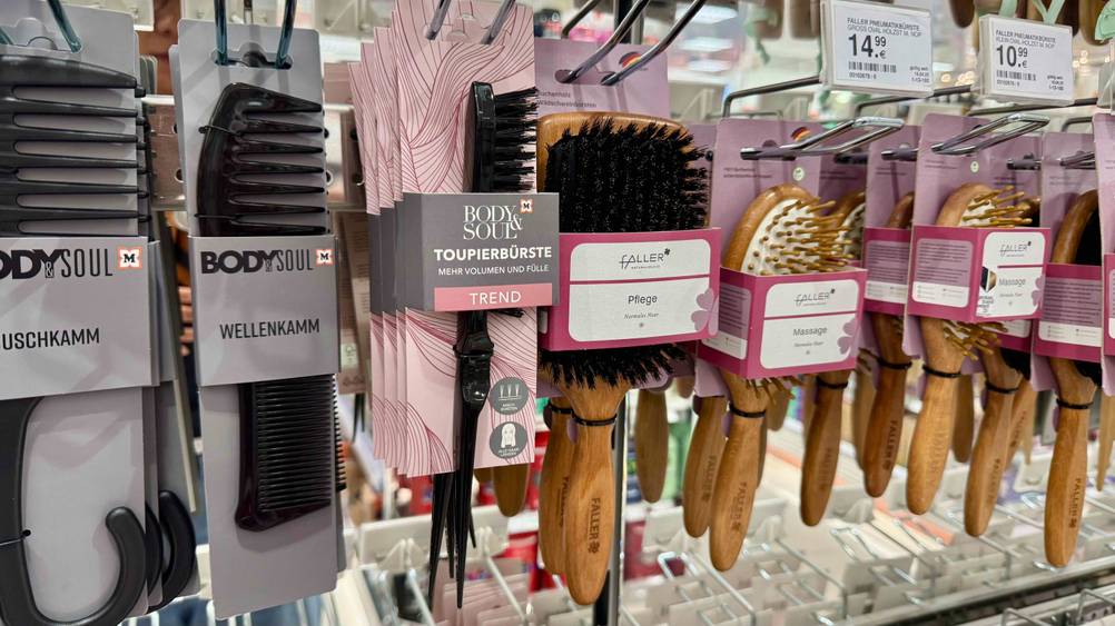 In einem Verkaufsregal neben anderen Produkten hängt die Toupierbürste im Test.