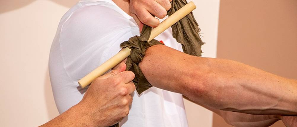 Tourniquet getestet: Ein improvisiertes Tourniquet am Arm eines Mannes