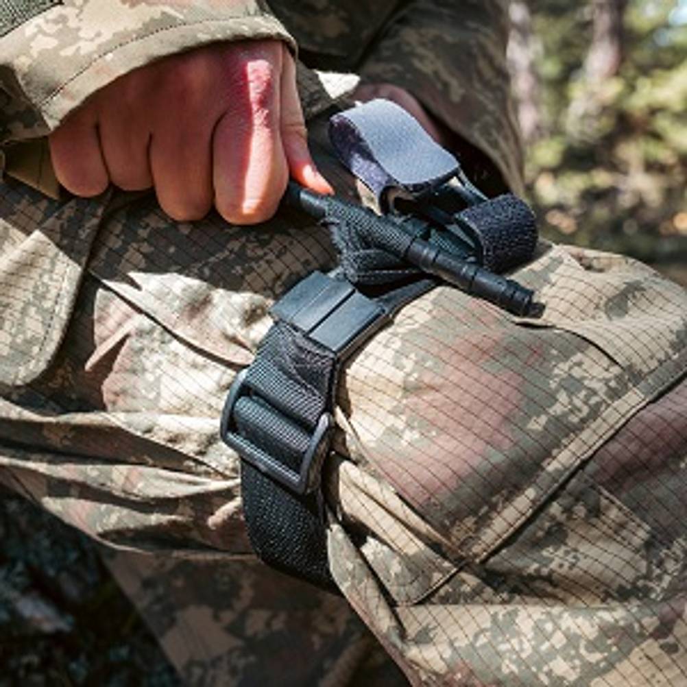 Tourniquet im Test: Soldat, der eigenes Bein mit einem Tourniquet abbindet