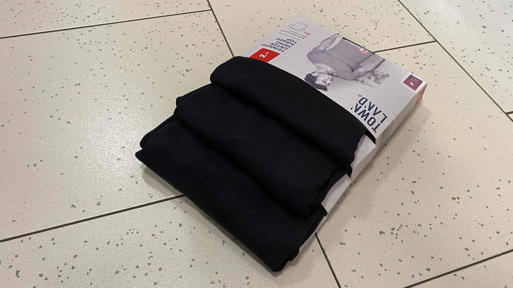 Im Test: Dreierpack Town Land Unterhemden für Herren liegt verkehrt und schräg auf Fliesen.