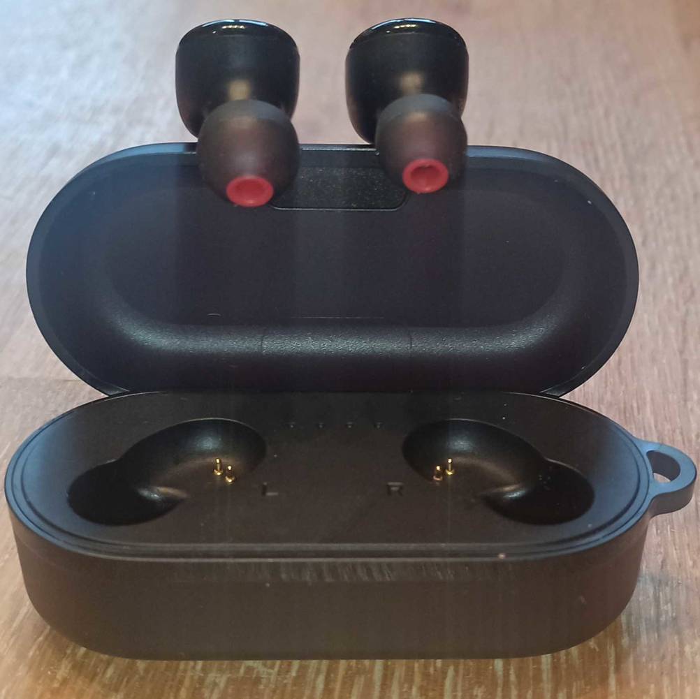 Tozo Bluetooth Kopfhörer hängen an geöffneter Box.
