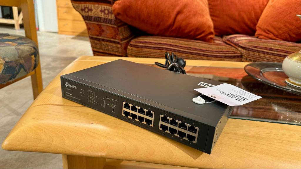 Im Test: Ein 16-Port-Gigabit-Switch steht auf einem Holz-Couchtisch in einem Verkaufsbereich.