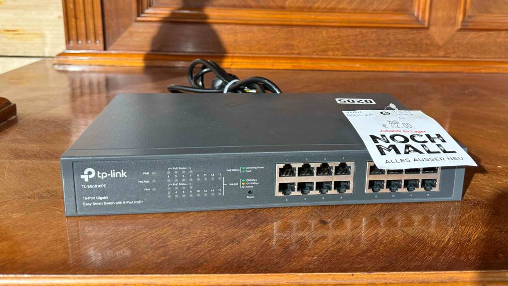 Ein 16-Port-Gigabit-Switch im Test befindet sich auf einem Holztisch.