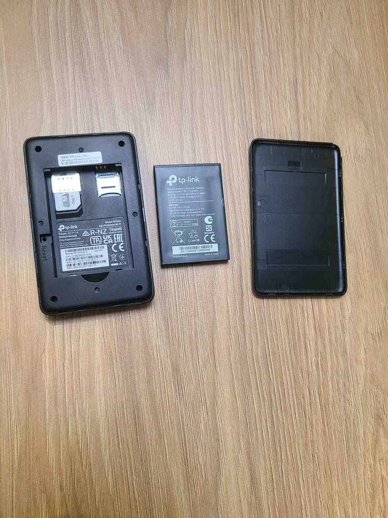 Der mobile WLAN-Router im Test, von oben betrachtet, liegt, zerlegt in drei Einzelteile, auf einer Holzoberfläche.