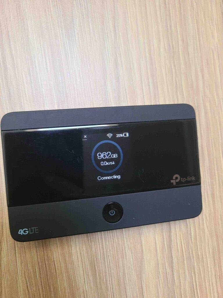 Der mobile WLAN-Router im Test, von oben betrachtet, steht auf einer Holzoberfläche.