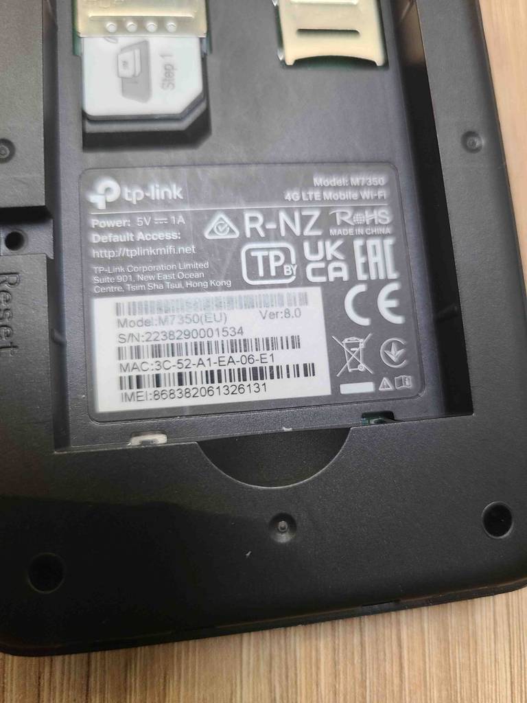 Detailansicht des geöffneten SIM-Karten-Bereichs inklusive Produktetikett unterhalb des mobilen WLAN-Routers im Test.