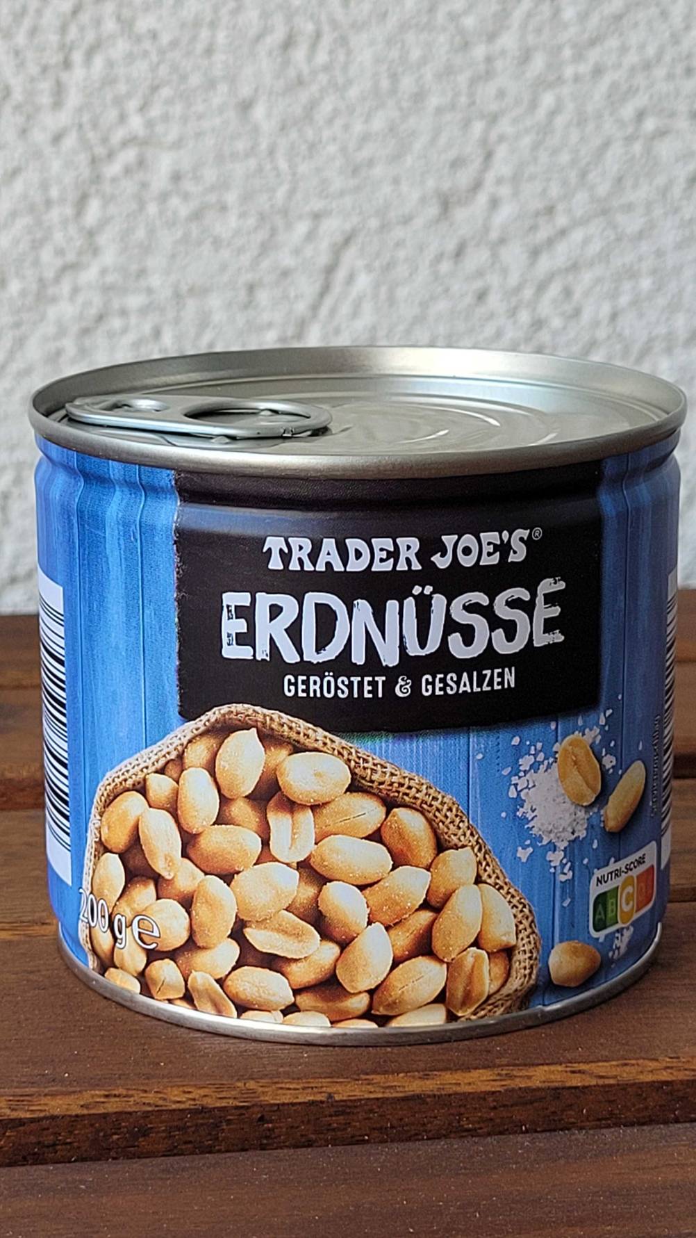 Eine Dose getesteter Erdnüsse von vorne auf einem Holztisch.