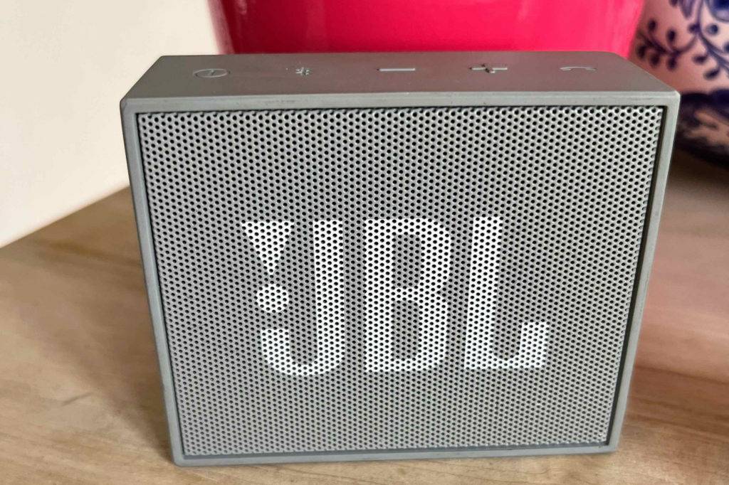 tragbarer Lautsprecher von JBL im Test liegt auf einem Holztisch.