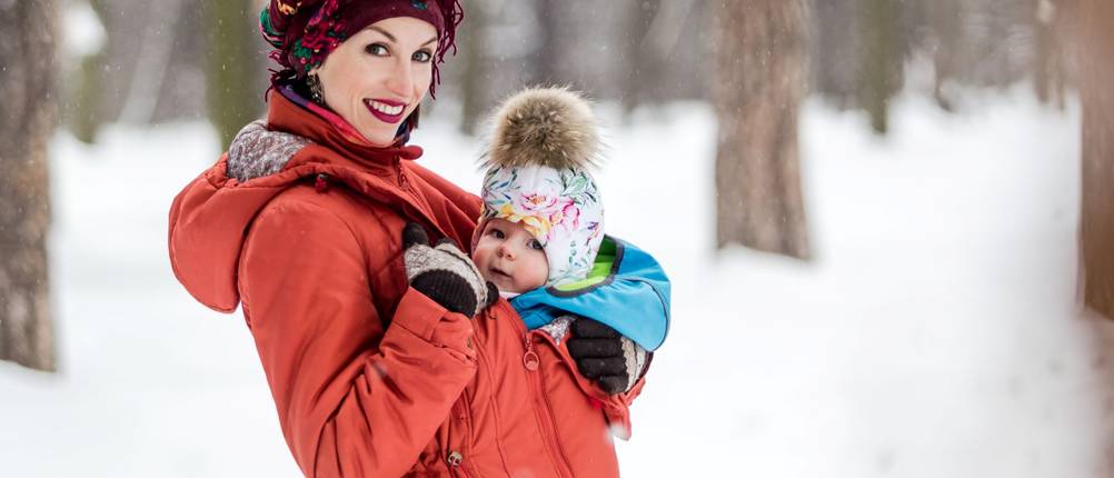 Tragecover im Test: Frau mit Baby in roter Tragejacke