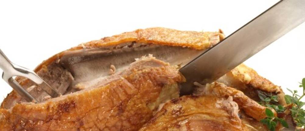 Tranchierbestck-Test: Ein Tranchierbesteck steckt in einem gegrillten Huhn.