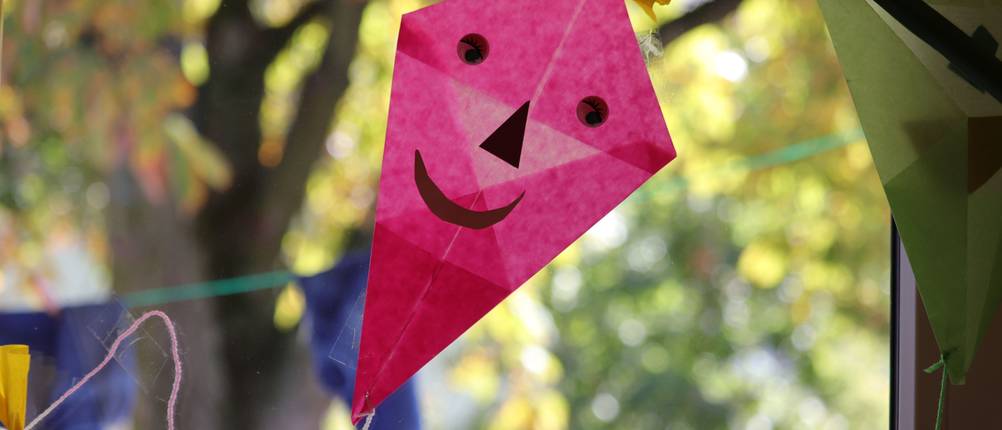 Transparentpapier-Test: Pinker Drache mit lächelndem Gesicht und gelber Schleife auf dem 