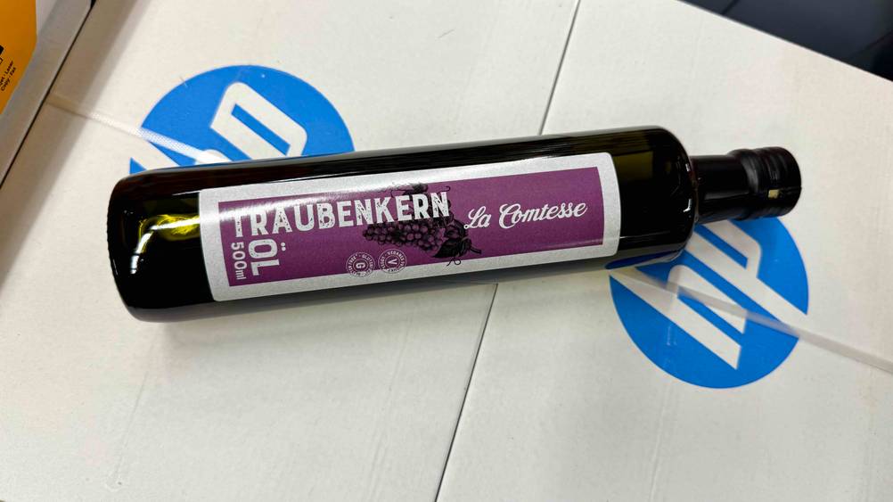 Auf einem hellen Karton liegt ein Traubenkernöl im Test horizontal.