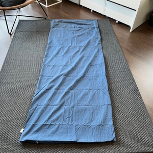 Traveler's-Pal-Hüttenschlafsack ausgerollt auf einem Teppich