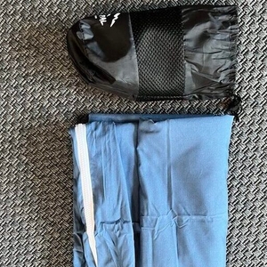 Gefalteter Traveler's-Pal-Hüttenschlafsack und leerer Transportbeutel auf einem Teppich