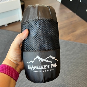 Hand hält Transportbeutel mit Traveler's-Pal-Hüttenschlafsack