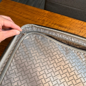 Eine Hand verschließt eine Seite des Innenraums vom Travelite City mit einem Reißverschluss