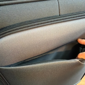 Eine Hand öffnet ein Fach an der Außenseite vom Travelite Derby