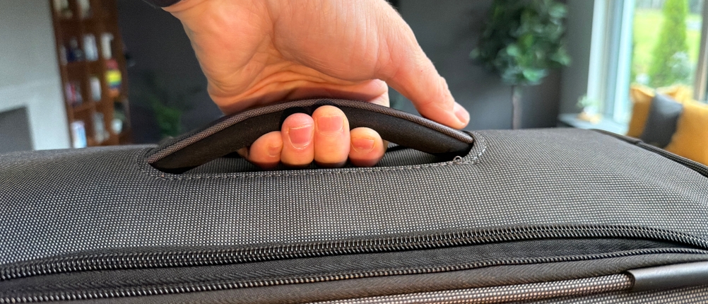 Eine Hand hebt den Travelite Derby am Griff hoch