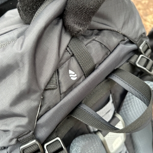 Am Deuter Aircontact Lite 50+10 ist eine Trinkschlauchausgangsöffnung im oberen Rückenbereich zu sehen. Der Rucksack ist in Nahaufnahme fotografiert.