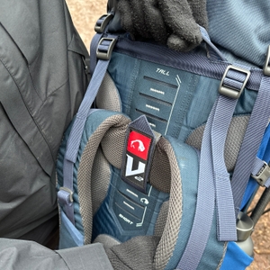 Nahaufnahme des V2-Tragesystems am Tatonka Yukon 60+10 mit gut sichtbaren Einstellschlaufen. Eine Hand greift in das Rückensystem.