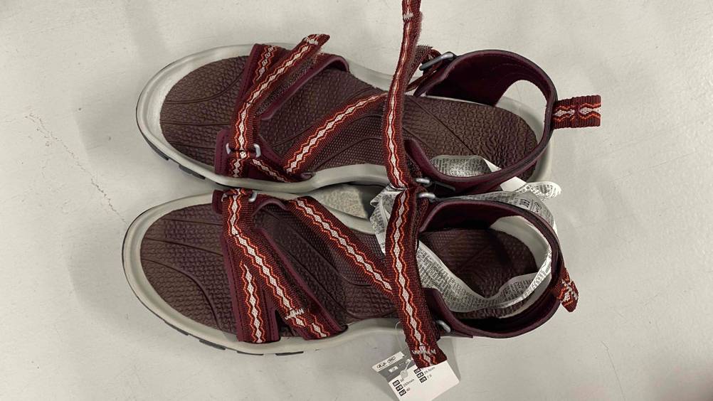 Auf dem Boden befindet sich ein getestetes Paar Trekkingsandalen für Damen.