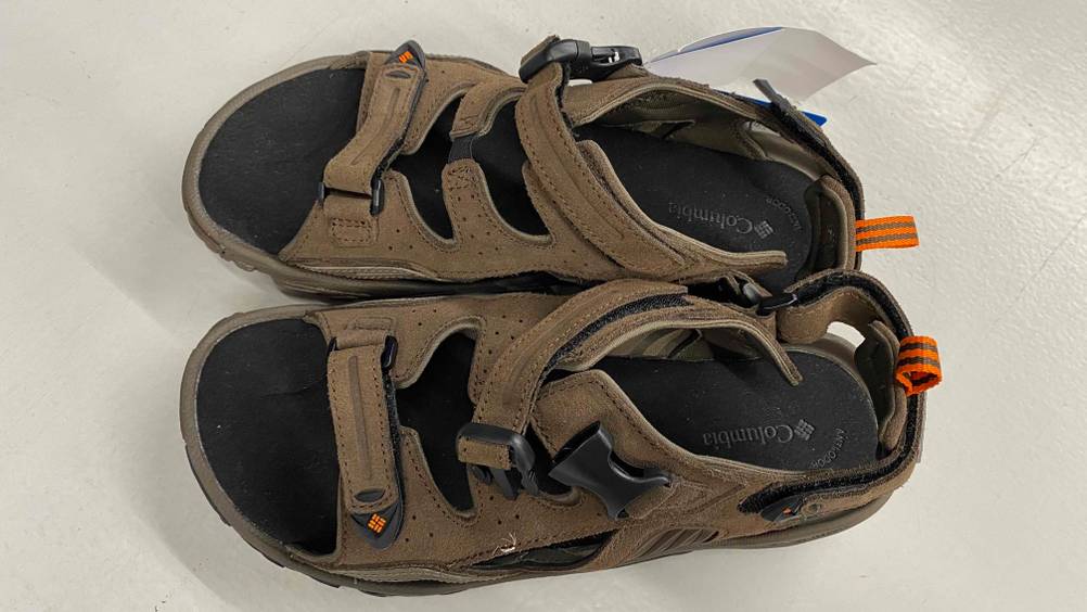 Auf dem Boden befindet sich ein Paar getestetes Trekkingsandalen für Herren.