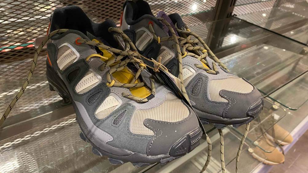 Ein Paar der getesteten Trekkingschuhe für Herren auf einem Glasregal von schräg vorne.