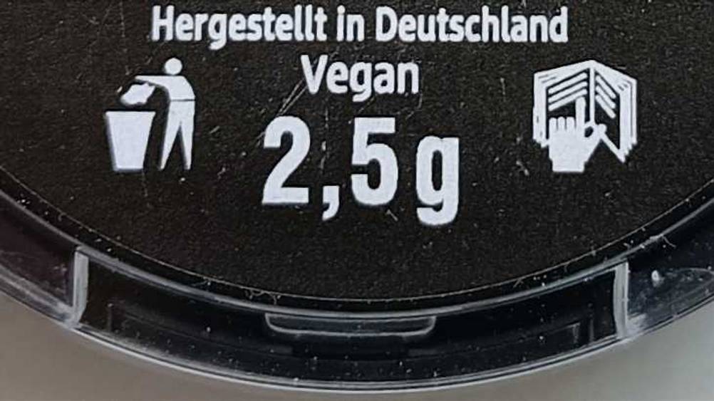 Lidschatten-Test: Detailansicht des schwarzen Tiegel-Bodens mit weißer Schrift.
