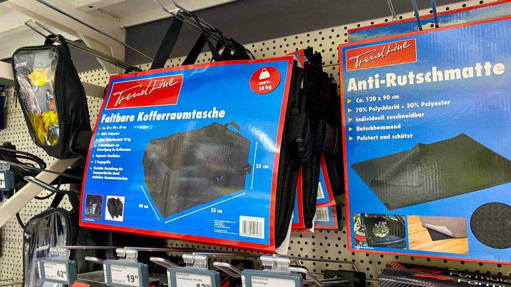Im Test: Eine Kofferraumtasche neben anderen Produkten im Regal hängend.