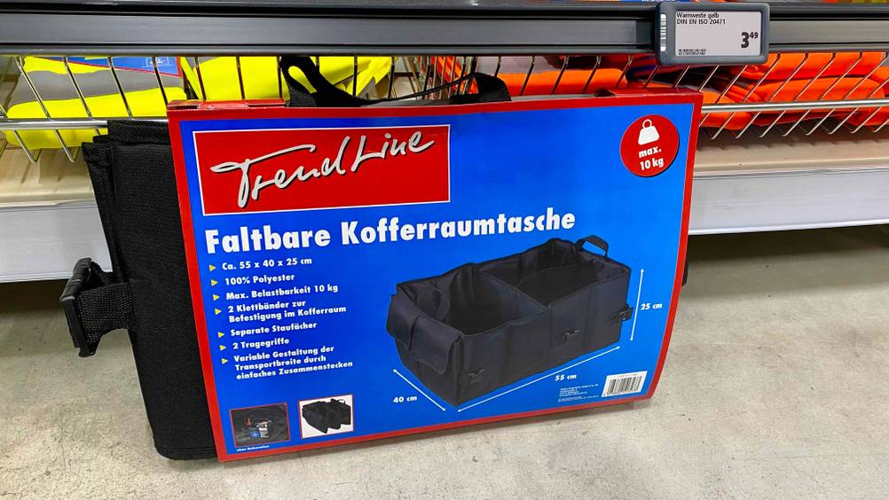 Eine getestete Kofferraumtasche originalverpackt vor einem Regal stehend.