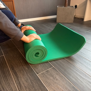 Eine Person rollt die Tresko-Gymnastikmatte zusammen