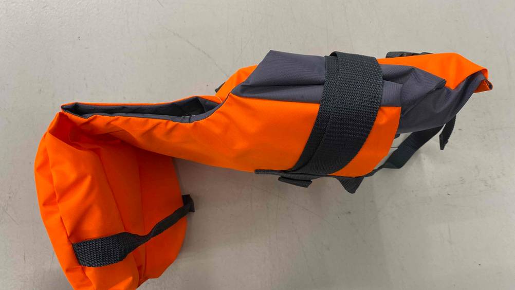 Eine getestete Rettungsweste für das Kind liegt seitlich auf einem hellen Boden.